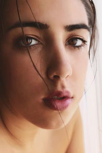 Close-up portrait of young woman at home