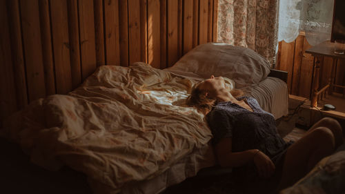 Woman leaning on bed at home