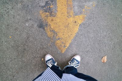 Low section of man standing on road