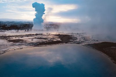 Smoke emitting from geyser against sky during sunset