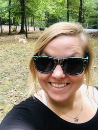 Portrait of a smiling young woman wearing sunglasses