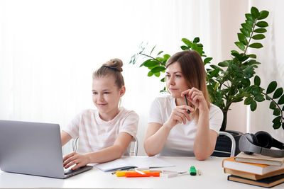 Mother helping daughter with homework