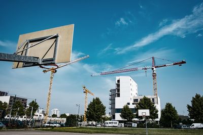 Cranes against sky in city