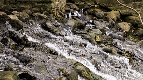 High angle view of stream flowing through rocks