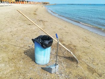 High angle view of garbage bin with rake at beach 