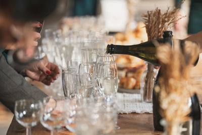 Close-up of man drinking glass on table