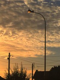 Low angle view of street light against cloudy sky