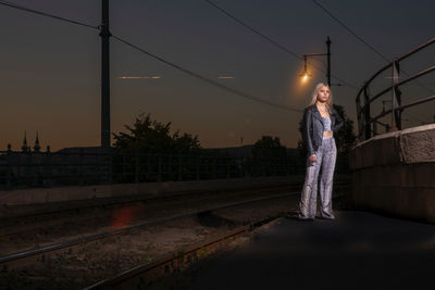 Woman standing on railroad track against sky