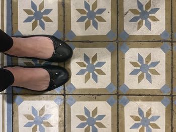 Low section of person standing on tiled floor