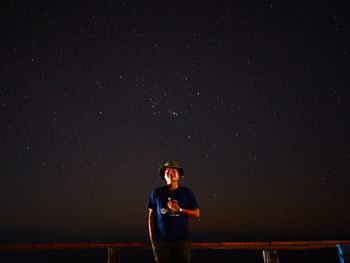 Full length of young man standing against sky at night