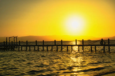 Silhouette pier on sea against sky during sunset