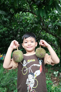 Portrait of smiling girl holding plant