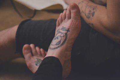 Low section of woman with tattoo on feet