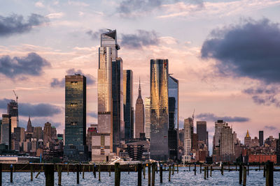 Modern buildings in city against sky during sunset