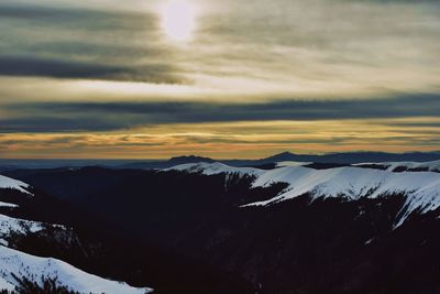 Scenic view of snowcapped mountains against sky during sunset