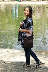 Portrait of smiling young woman standing in lake