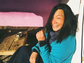 Close-up of woman smiling while sitting by table