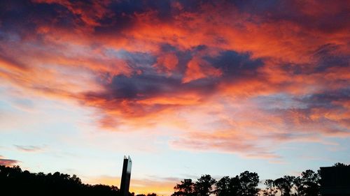 Silhouette of trees against cloudy sky