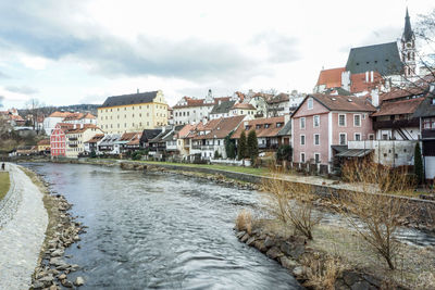 River amidst buildings in town against sky