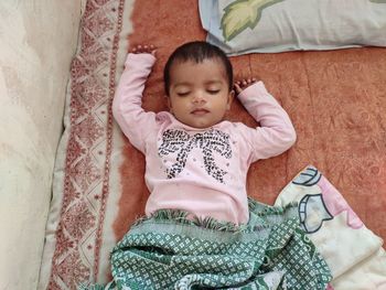 High angle view of baby lying on bed at home