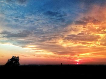 Scenic view of silhouette field against romantic sky at sunset