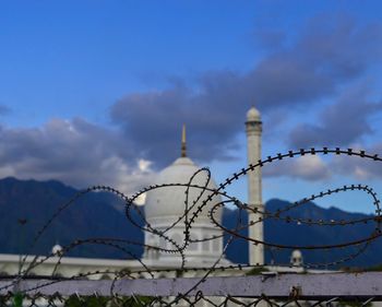 Low angle view of barbed wire against sky