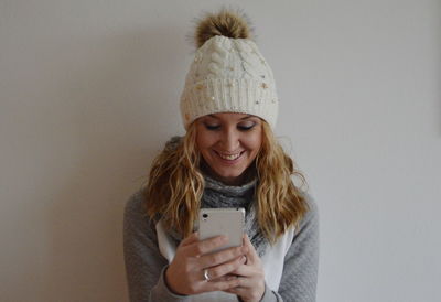 Portrait of young woman standing against white background