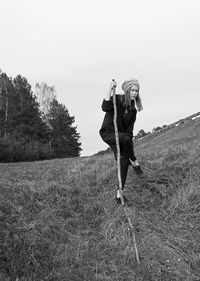 Full length of woman standing on field against clear sky