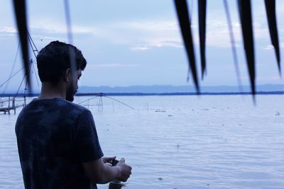 Man standing in sea against sky