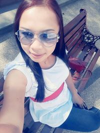 High angle portrait of girl sitting at sunglasses