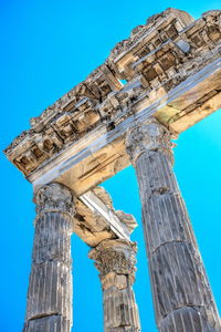 Low angle view of old ruins against blue sky