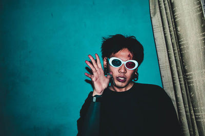 Portrait of young man standing by swimming pool