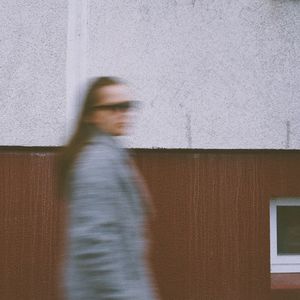 Side view of woman standing against wall