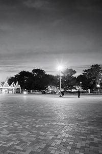 People on street by building against sky