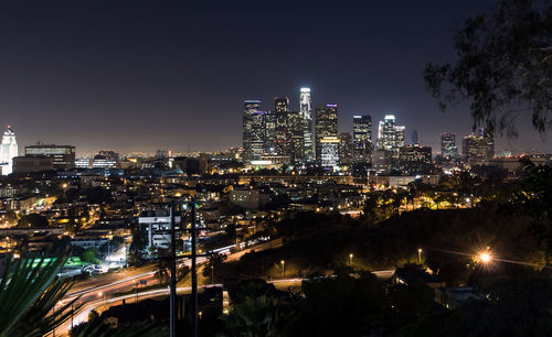 Illuminated cityscape against sky at night