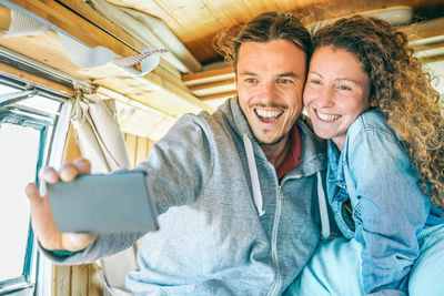 Happy couple taking selfie with phone in motor home