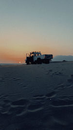 Boat sailing in sea against clear sky during sunset