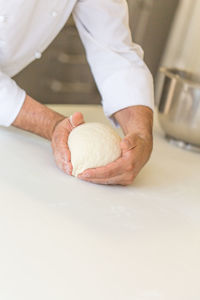 Close-up of man kneading dough