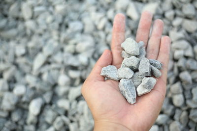 Close-up of hand holding pebbles