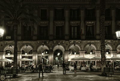 People walking in front of building at night