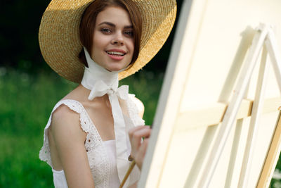 Side view of woman wearing hat standing outdoors