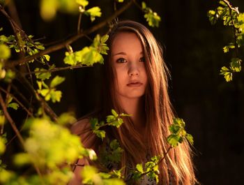 Close-up portrait of teenage girl by plant