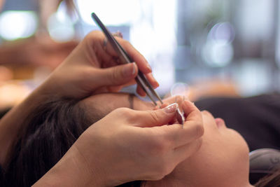 Cropped hands of woman giving treatment to customer at spa