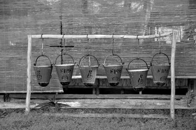 Row of fire buckets hanging on bamboo at yard