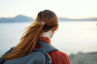 Rear view of woman looking at sea against sky