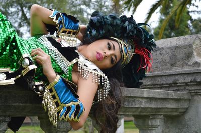 Young woman wearing costume lying on railing