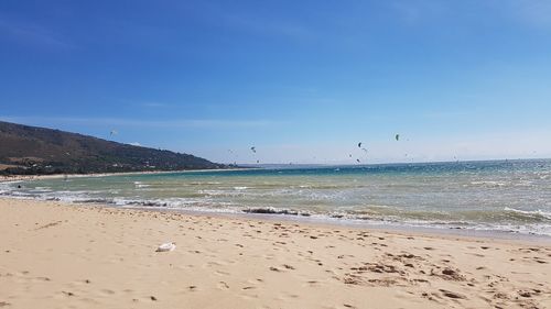 Scenic view of beach against blue sky