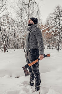 Side view of man on snow covered field