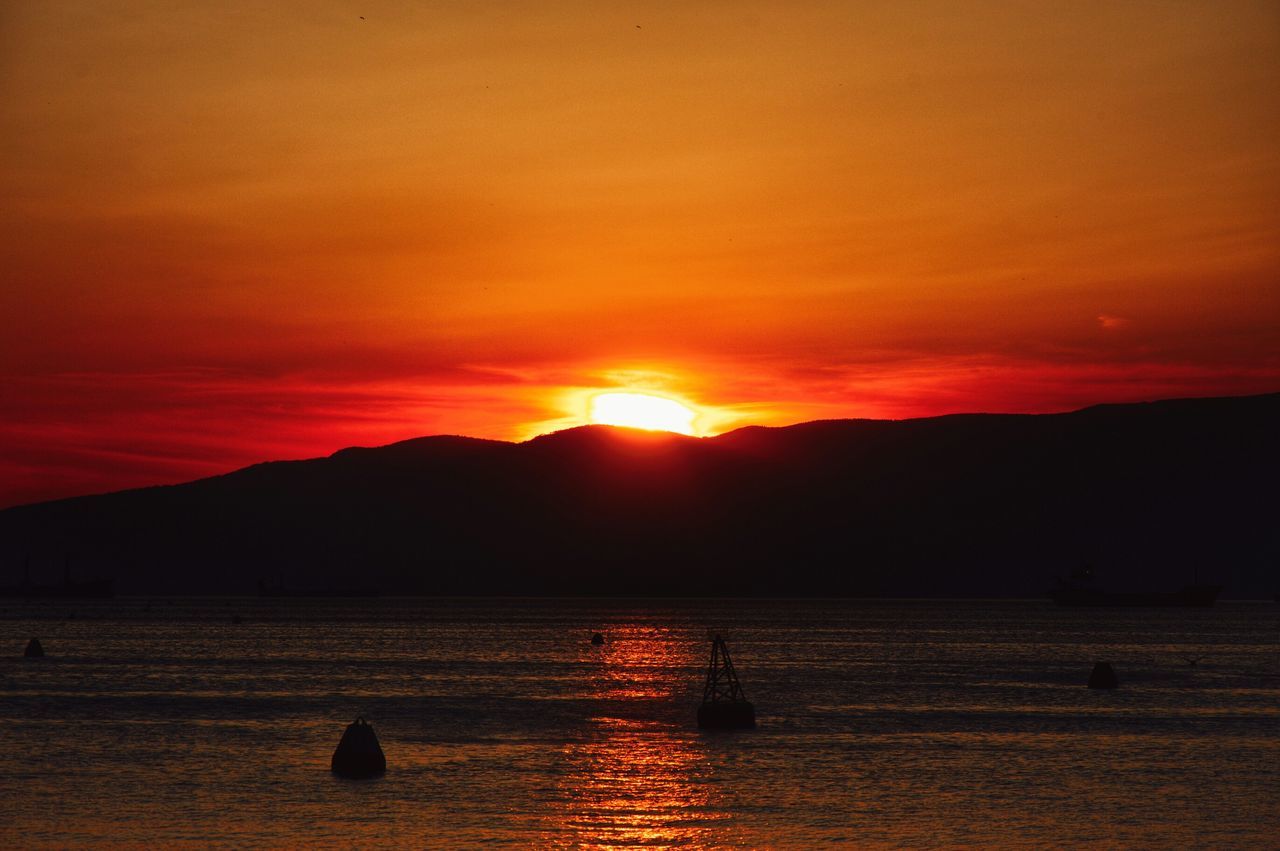 sunset, orange color, water, scenics, tranquil scene, silhouette, tranquility, beauty in nature, mountain, sky, sun, idyllic, nature, sea, mountain range, lake, reflection, cloud - sky, waterfront, dramatic sky