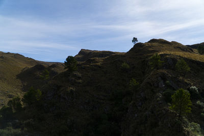 Low angle view of rocks on mountain against sky